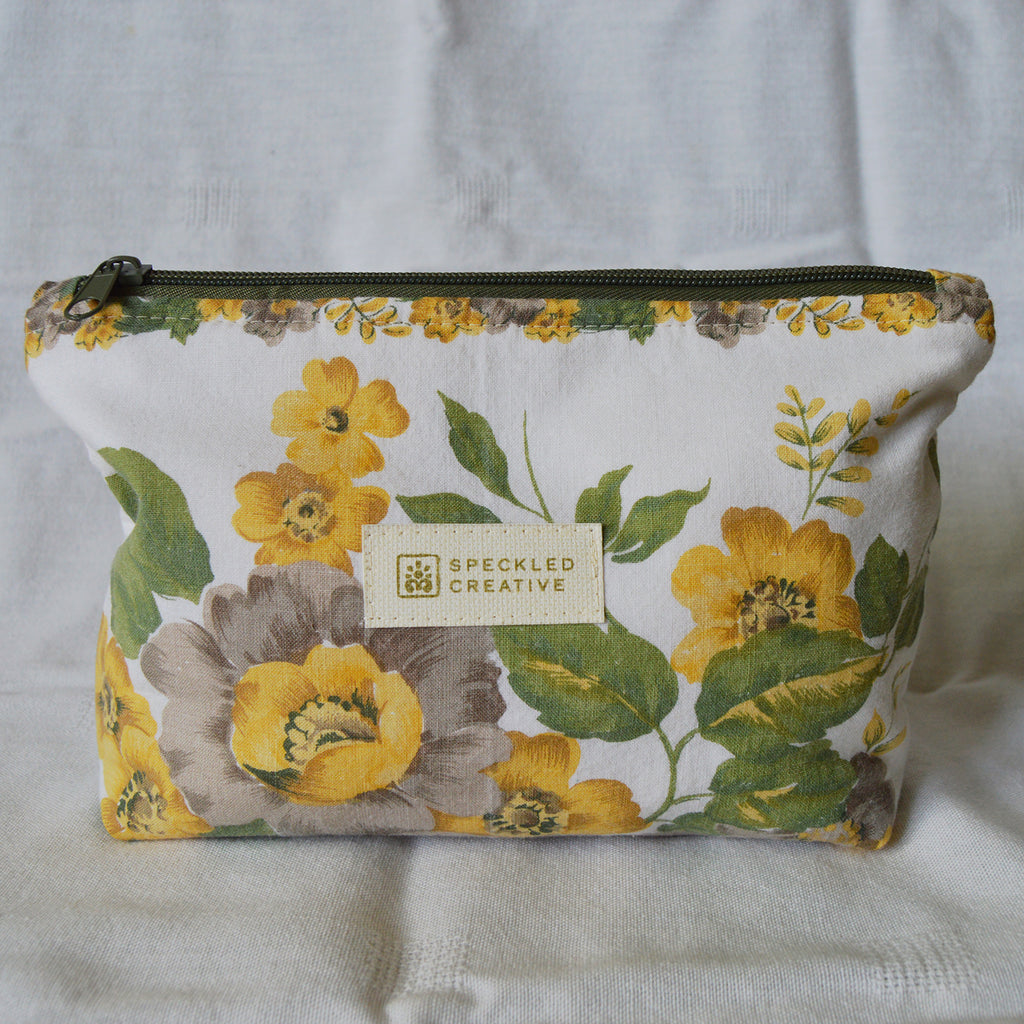 Floral pouch with 'Speckled Creative' label on a white background