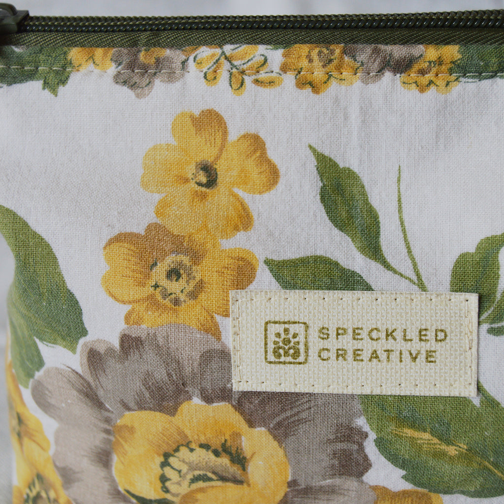 Close up of floral-patterned pouch with 'Speckled Creative' label