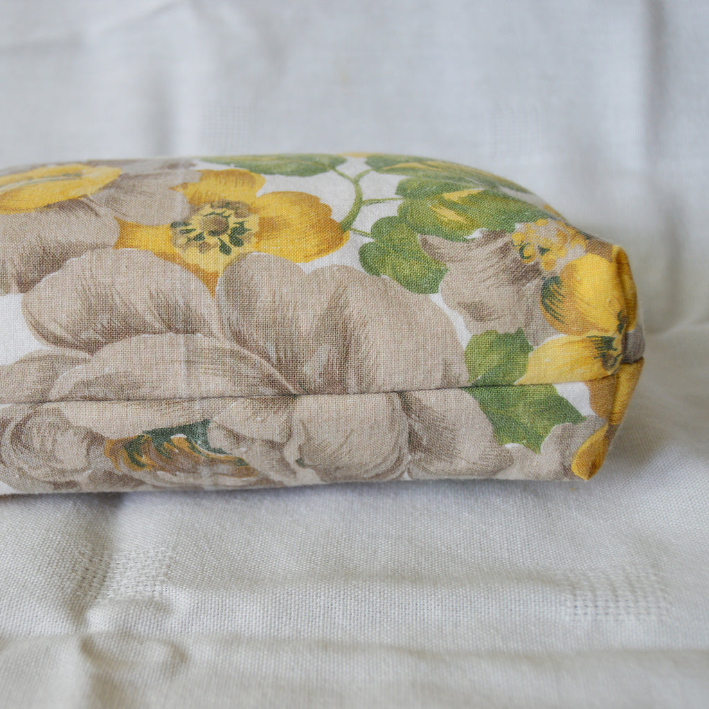 Bottom of pouch with floral-patterned fabric roll on a white background