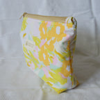 Floral patterned pouch with a visible brand label on a white background