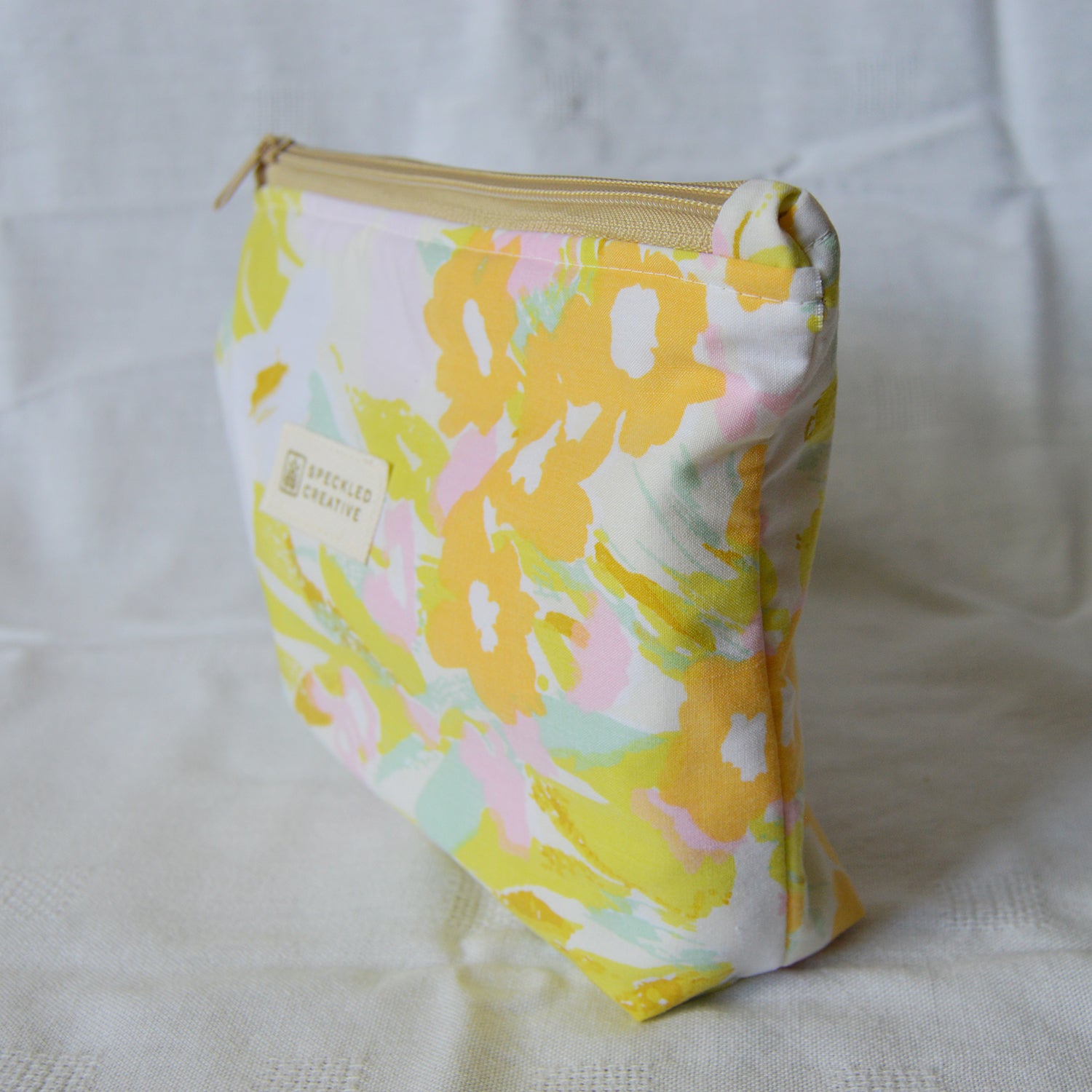 Floral patterned pouch with a visible brand label on a white background