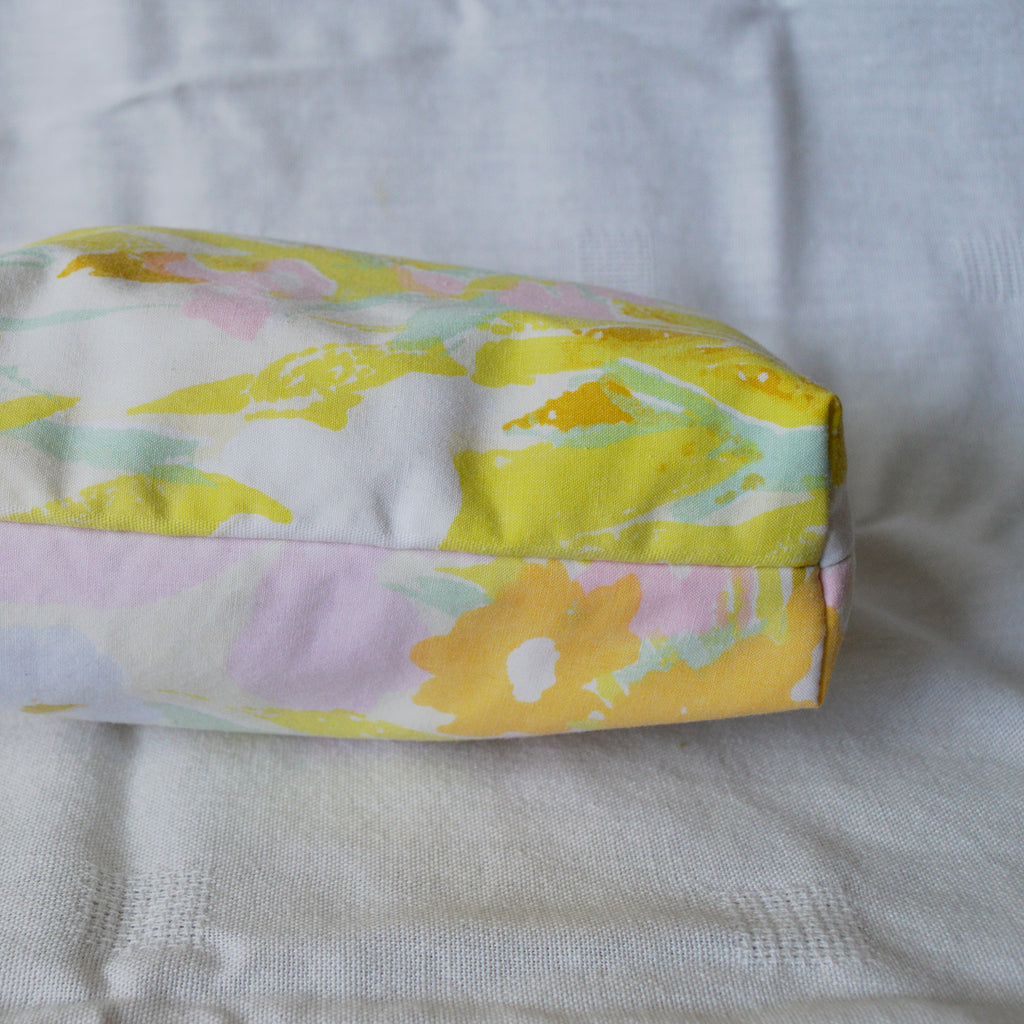 Bottom of pouch with floral-patterned fabric on a white background