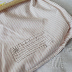 Close-up of a label on a pink textured fabric with a blurred background