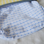 Close-up of a blue and white patterned fabric with a label on a textured surface.